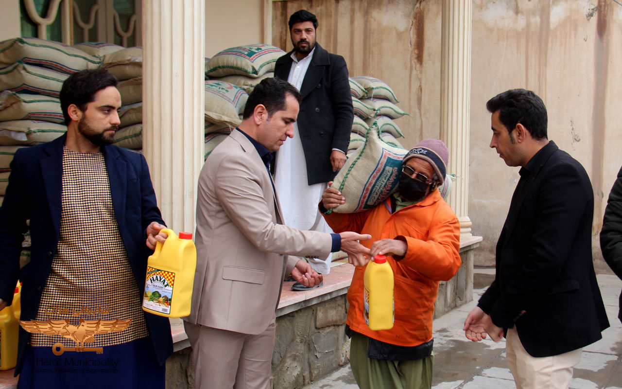 Distribution of food items to the orange-clad Herat Municipality by a charity